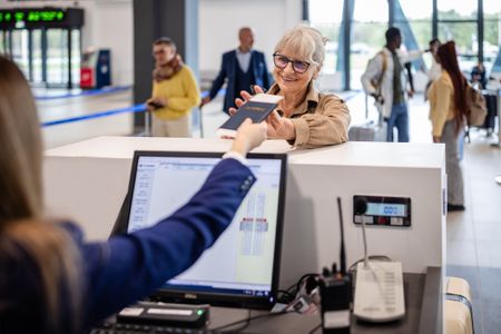 Woman receives passport back at airport counter