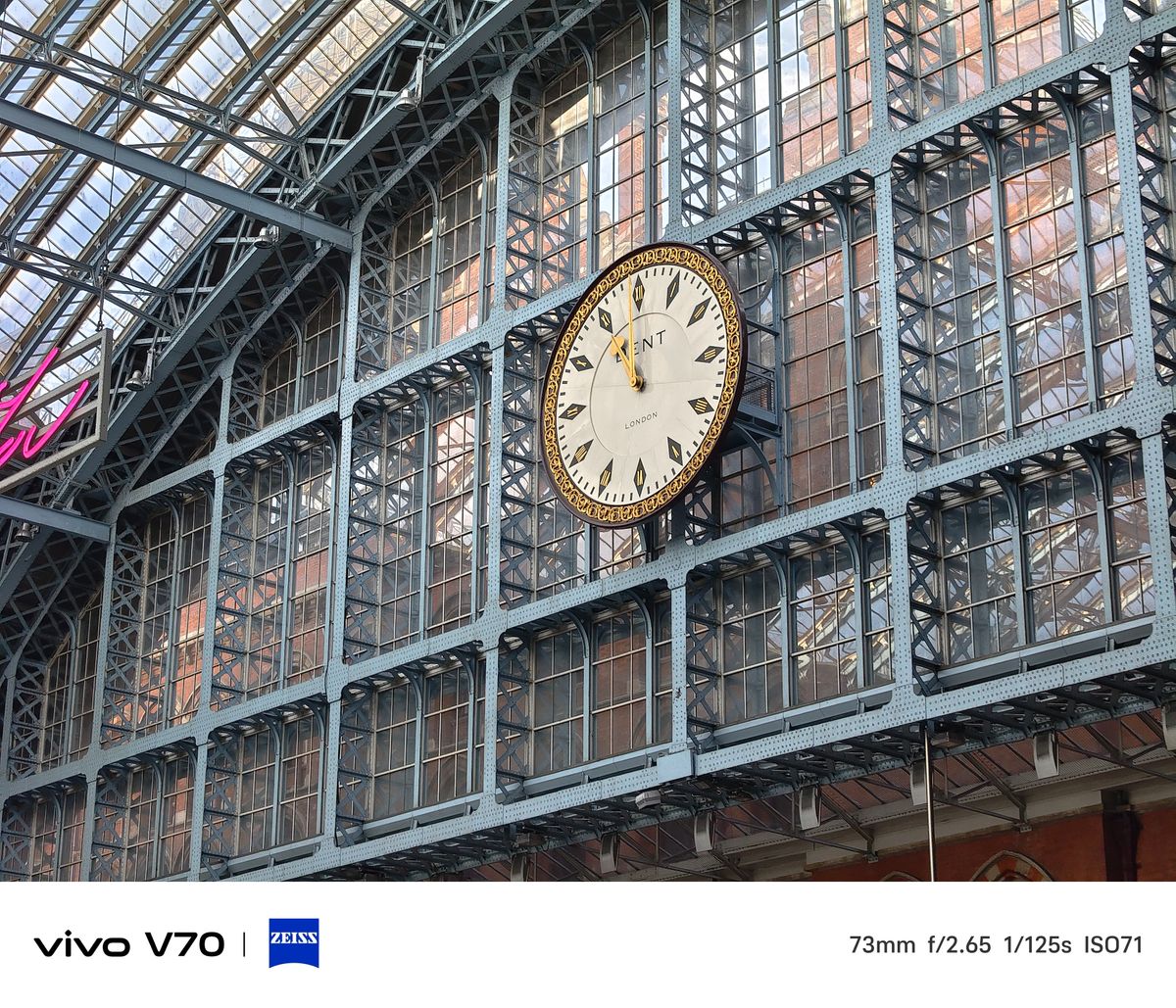 Medium telephoto shot of the large ornamental clock mounted on the station&rsquo;s glass wall.