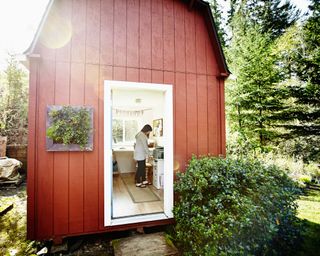 red external building in the garden with woman inside