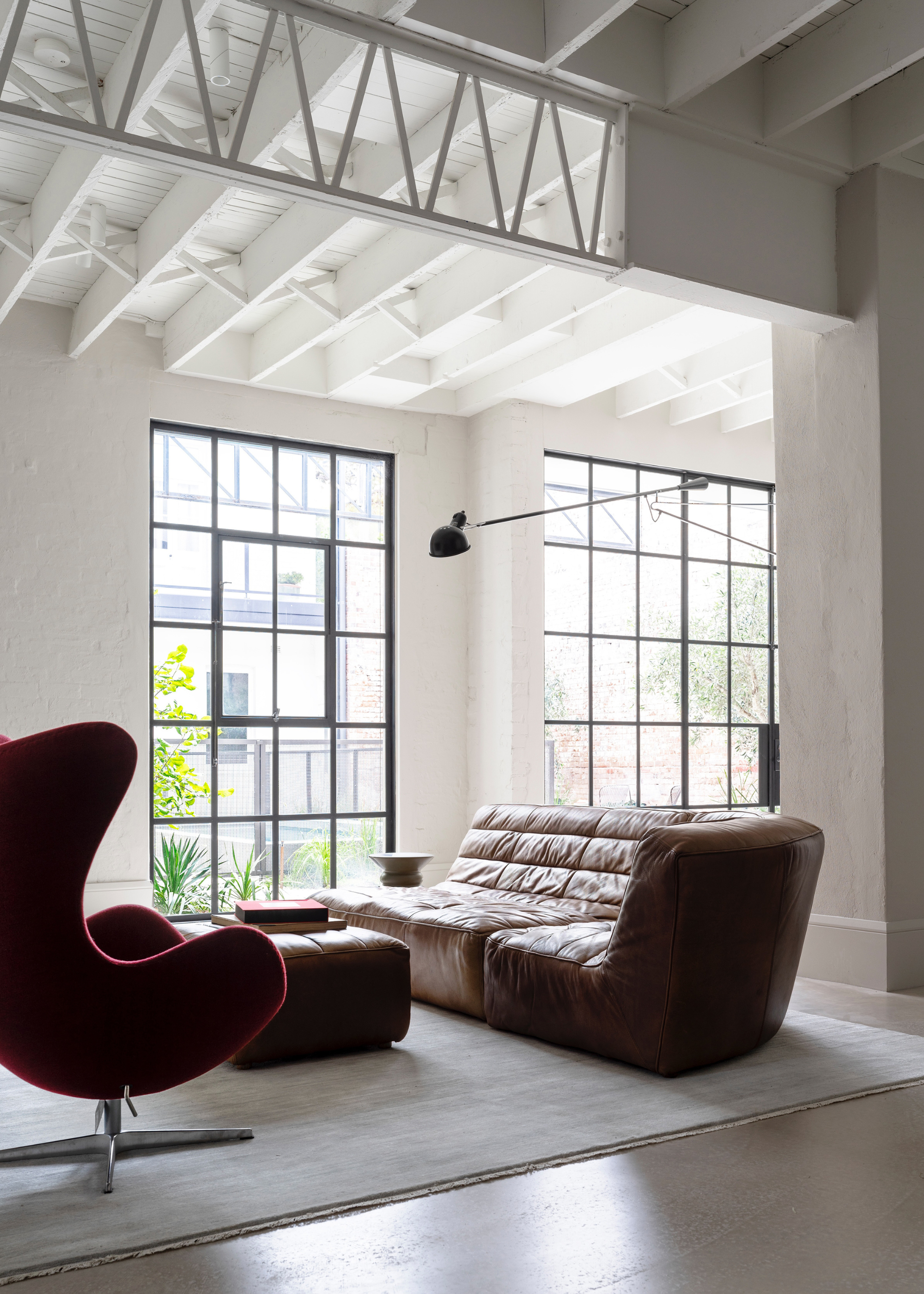 modern, white loft space with slick furnishing and floor to ceiling windows
