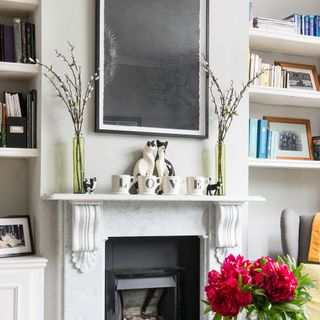White living room with white fireplace and art on the wall above