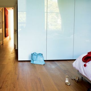 bedroom with wooden flooring and blue cabinet