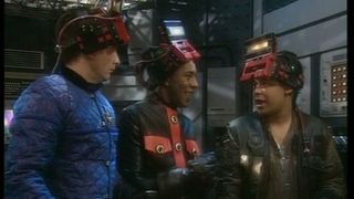 Still from the British sci-fi sitcom called Red Dwarf. Here we see Rimmer, the Cat, and Lister wearing virtual reality helmets.