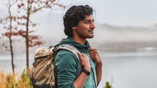 Man with backpack wearing Fitbit Charge 5