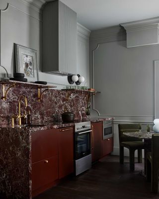 a grey kitchen with red cabinets and marble countertops