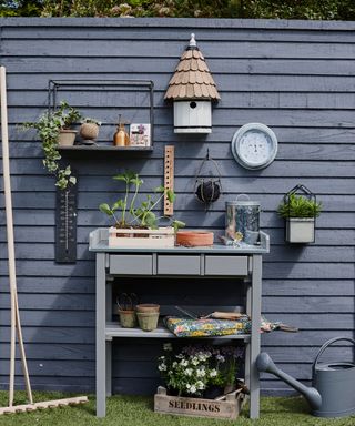 garden area with blue wooden fence and table