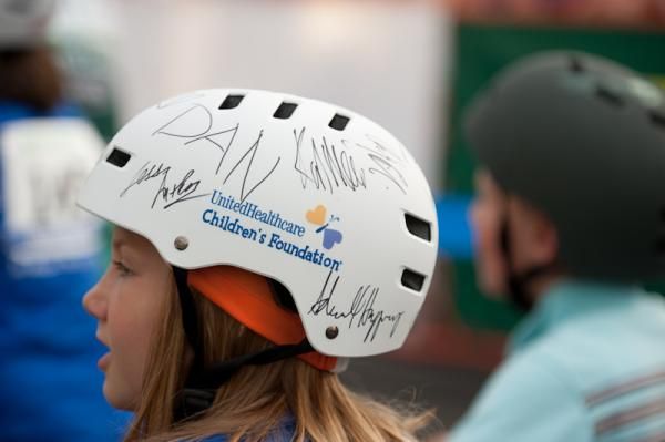 A kid's ride participant with one of the giveaway helmets signed by the United Healthcare team.