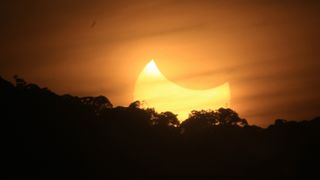 A partial solar eclipse is seen from Langkisau hill on March 9, 2016 in Painan, West Sumatra Province, Indonesia.