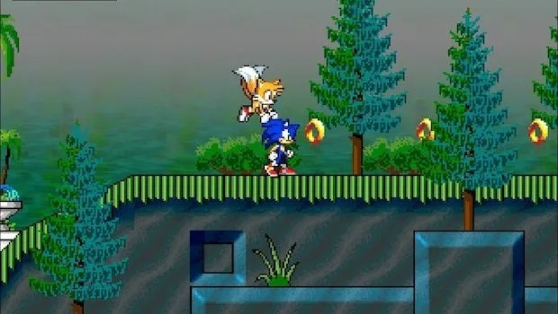 Sonic Chaos screenshot of Tails going to lift up Sonic off a grassy platform where gold rings can be see in the air
