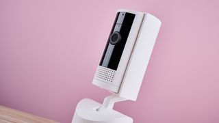 A view of the camera and privacy cover against a pink background.