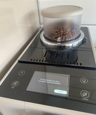 De'Longhi Rivelia coffee maker with screen prompt that says 'The technicalities are done. Let's get to know one another'