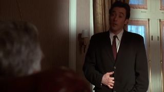 John Cusack in a suit and tie, looking a little nervous in Grosse Pointe Blank