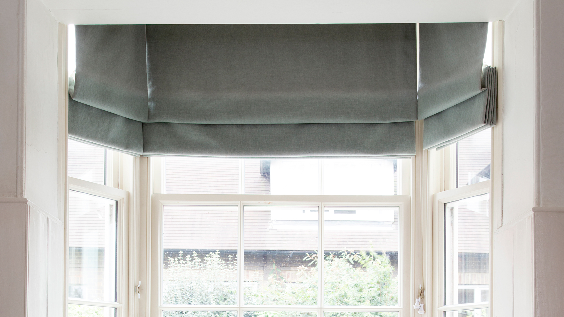 Close up of a dark grey blinds dressing a traditional sash window