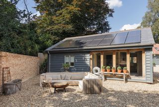 annexe with solar panels and blue cladding