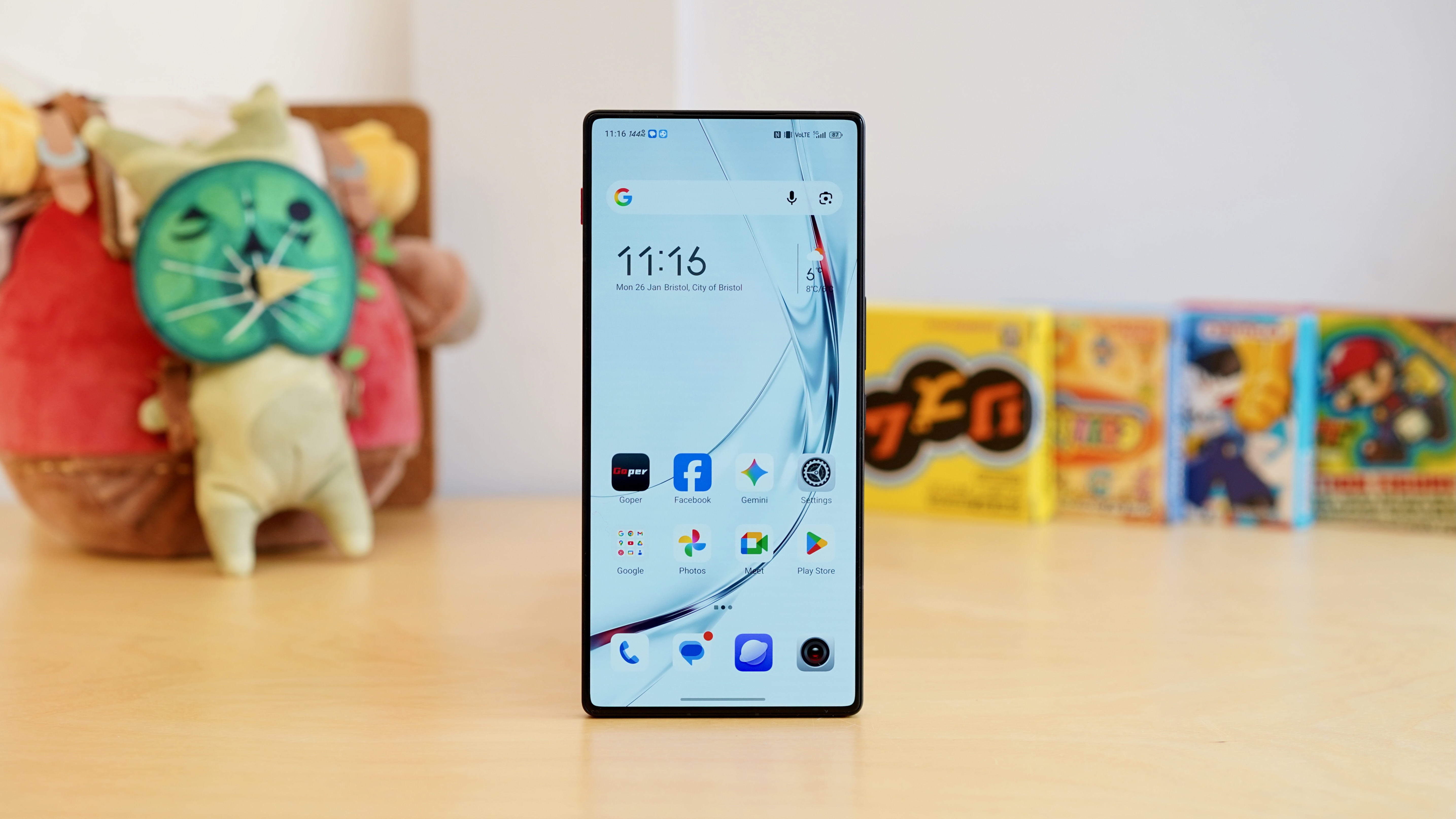 The RedMagic 11 Air Standing Upright on a Table With Games in the Background