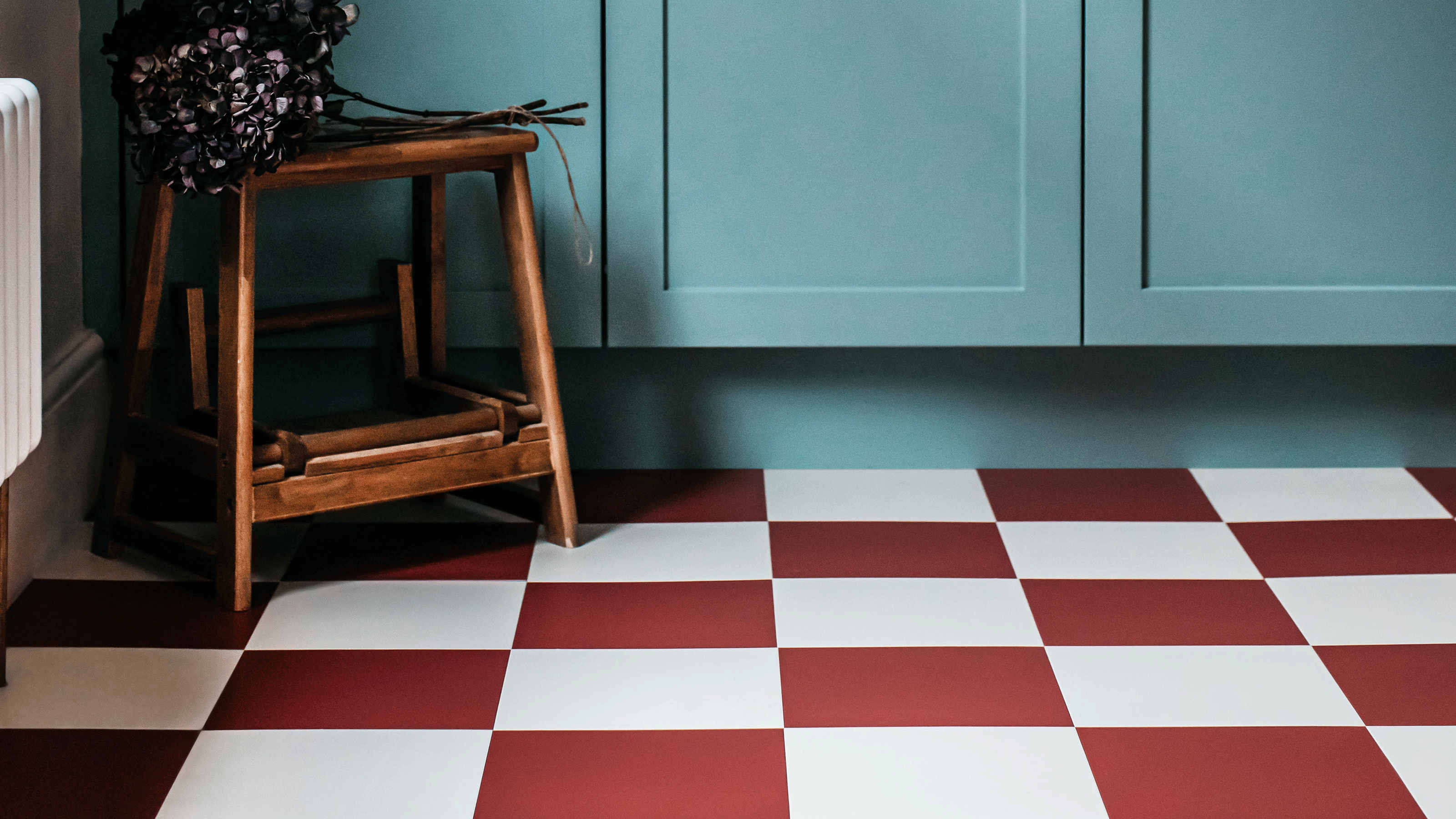Kitchen with blue cabinetry and red and white checkered flooring