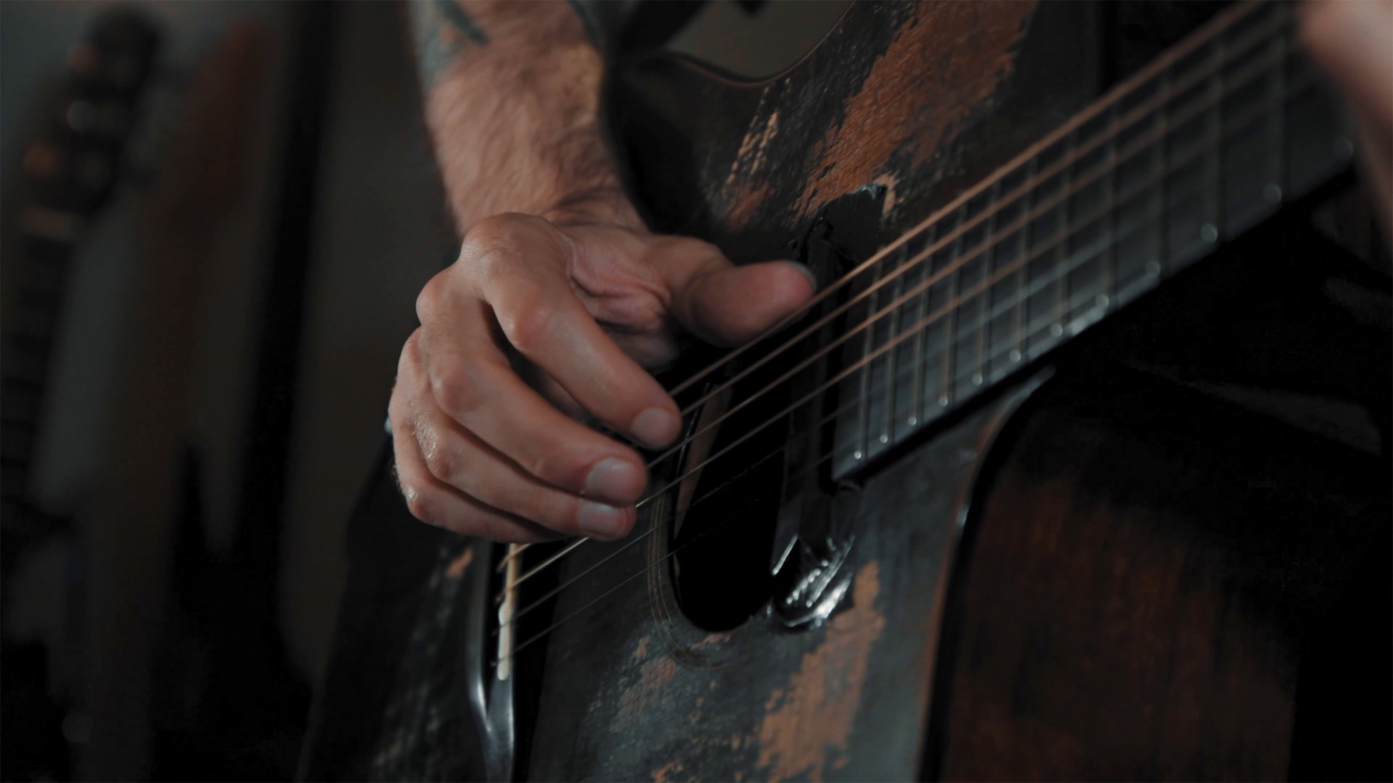 A publicity photo of Jon Gomm playing a guitar equipped with the Fishman Jon Gomm Signature Series Powertap Earth Pro pickup system