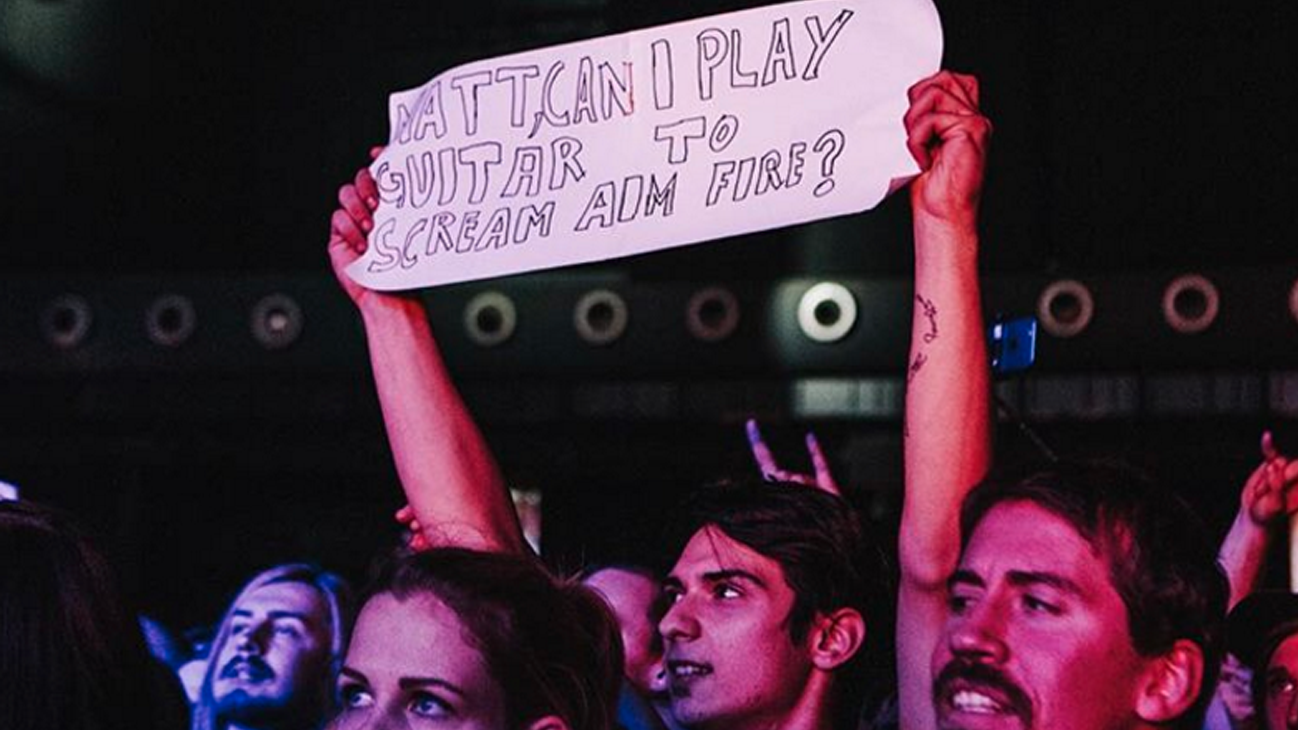 A picture of a Bullet For My Valentine fan holding up a sign asking to play live with the band in Austria