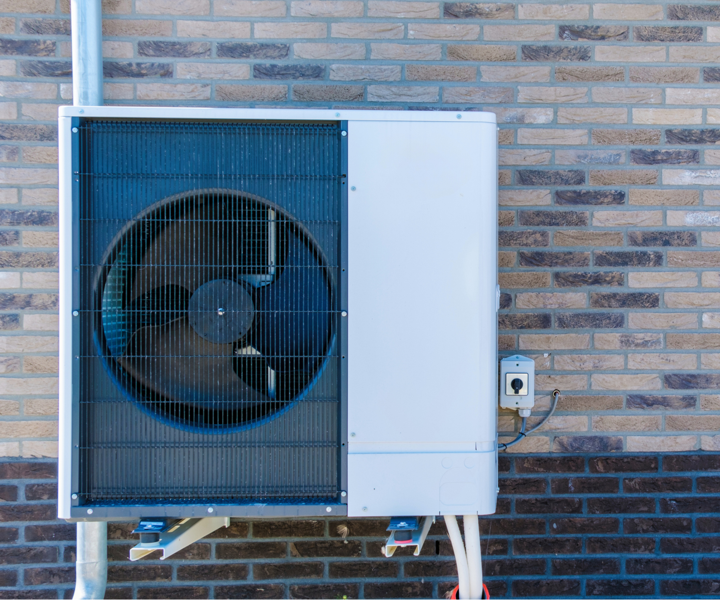 heat pump outside building with brick walls