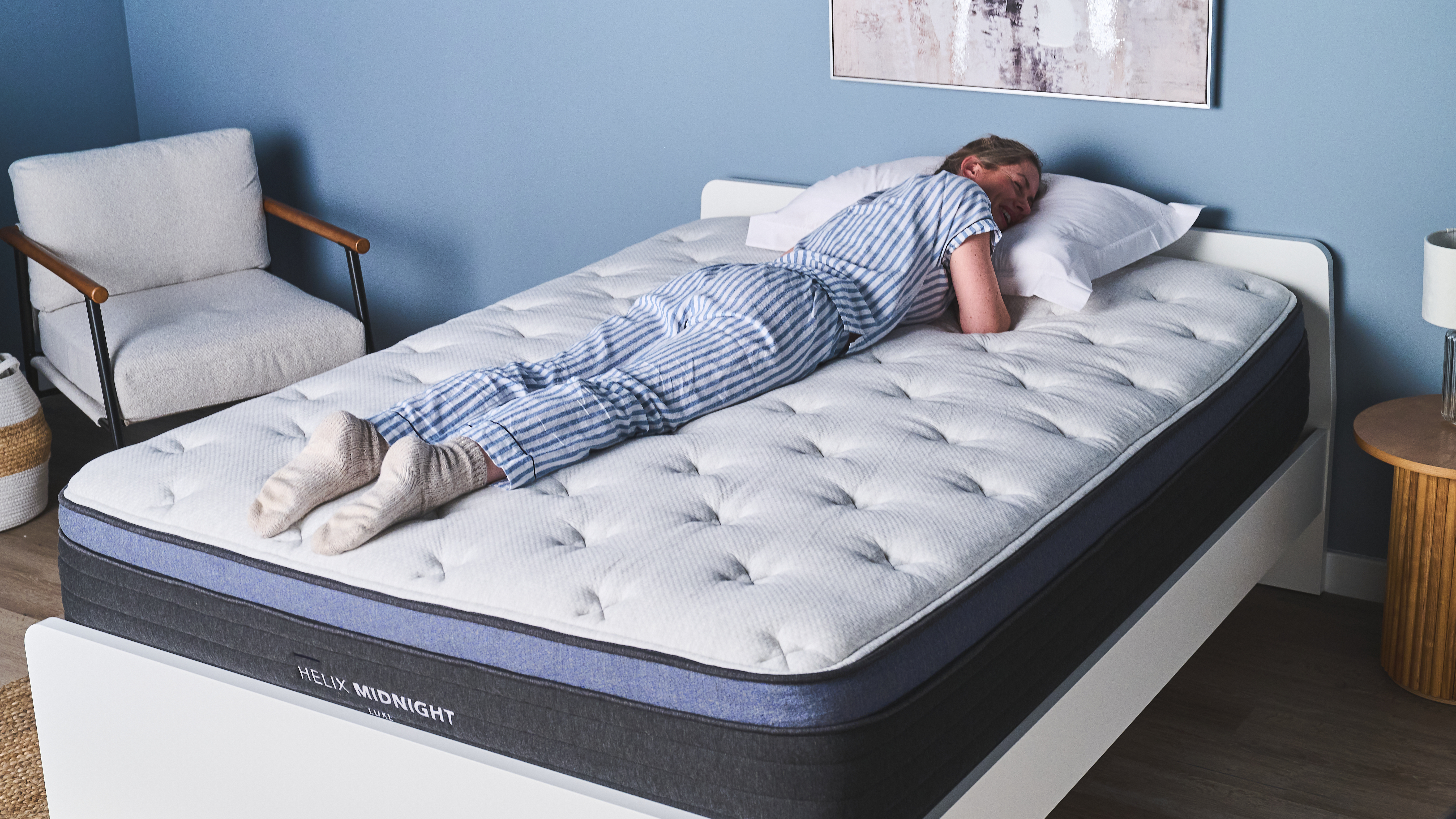A tester sleeps on her stomach while testing the medium-firm Helix Midnight Luxe mattress.