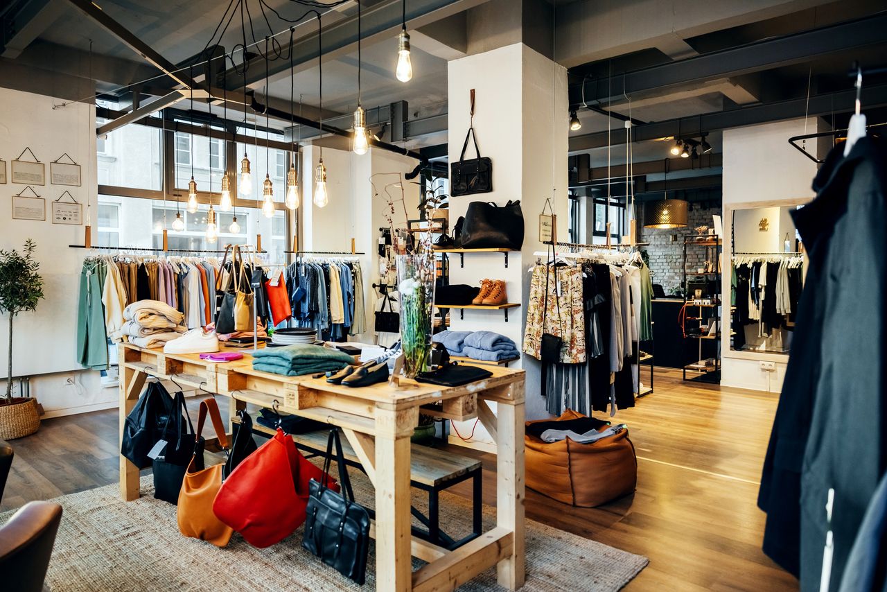 The retail displays and items of clothing on display in a fashionable high street clothing store, with no people.