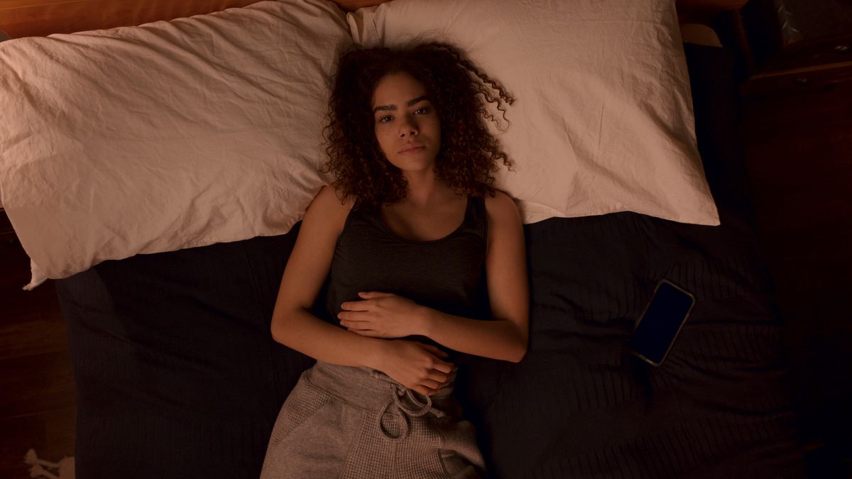 Antonia Gentry as Ginny lying down distraught in her bed in Ginny &amp; Georgia season 2