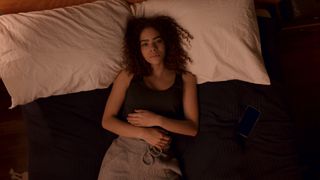 Antonia Gentry as Ginny lying down distraught in her bed in Ginny & Georgia season 2