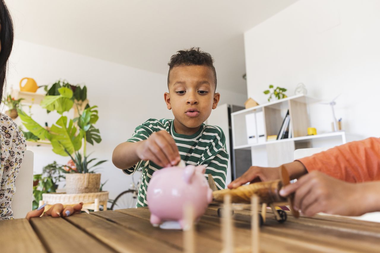 Child putting money into piggy bank