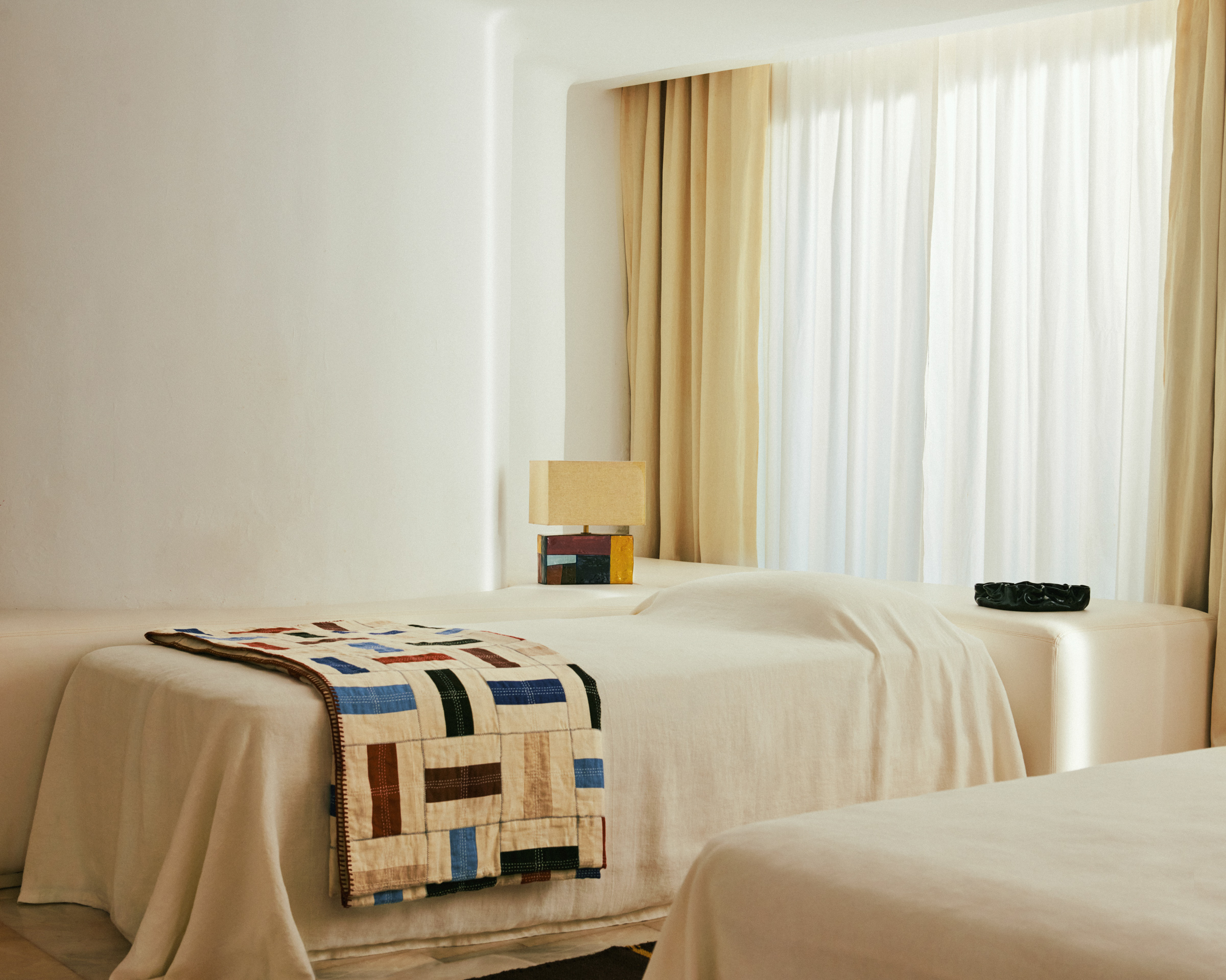 patchwork blanket on a bed in neutral interior