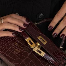 Dark burgundy nails and Kelly bag