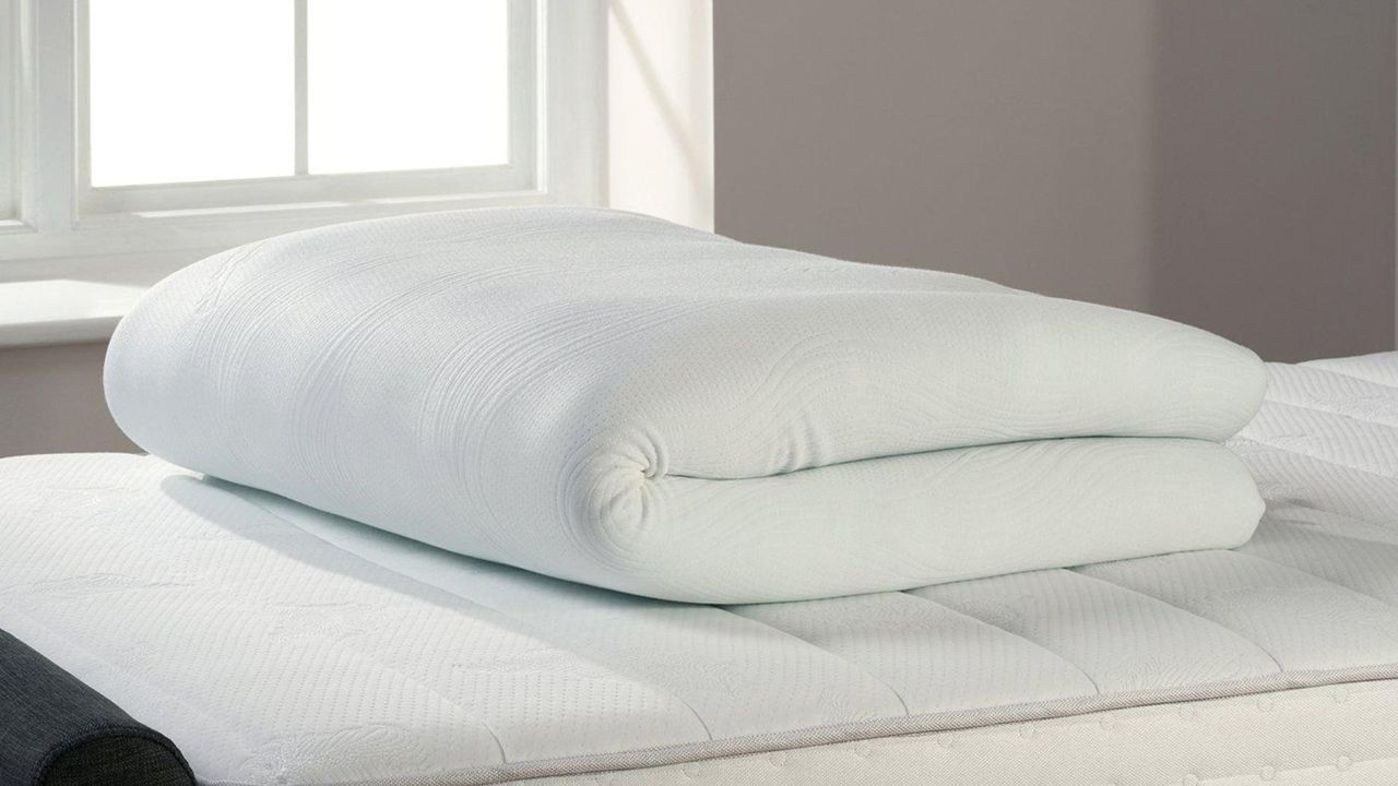 TheraPur ActiGel Cool Mattress Topper on a bed, rolled up