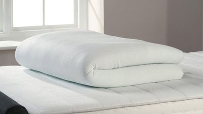 TheraPur ActiGel Cool Mattress Topper on a bed, rolled up