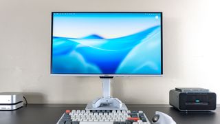 A desk setup built around the MSI Pro Max 271UPXW12G monitor with a Mac mini M4 on the left and a mini PC on top of an eGPU on the right
