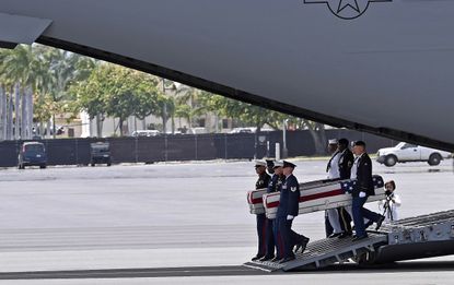 Pallbearers carry remains believed to belong to U.S. service members