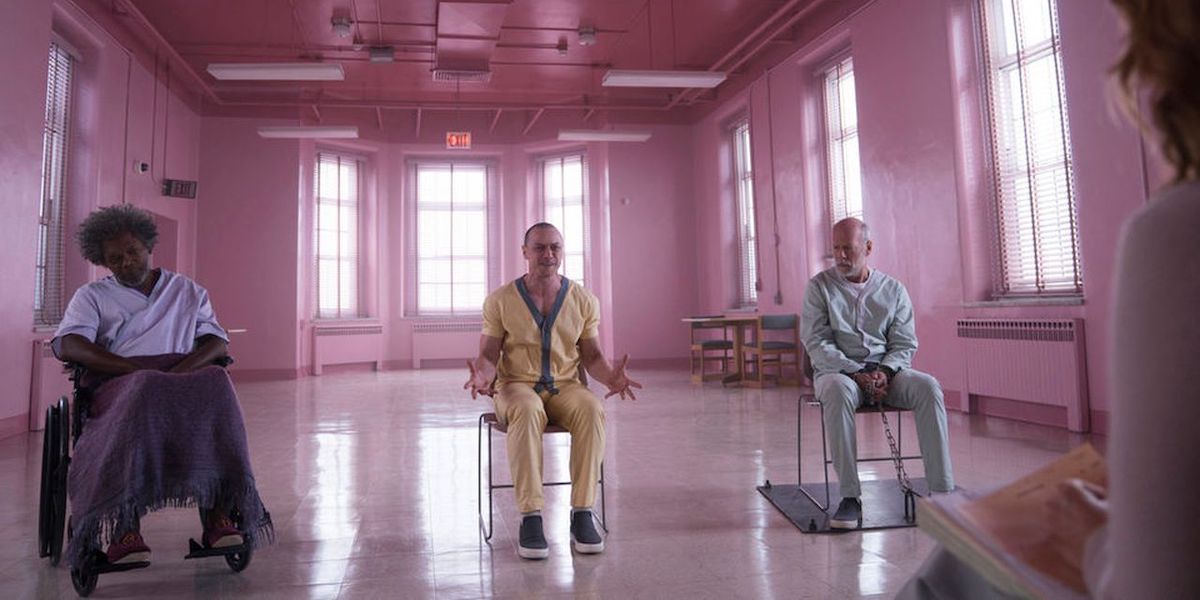 Elijah Price, Kevin Crumb and David Dunn sit in chairs in a pink room in &#039;Glass&#039;