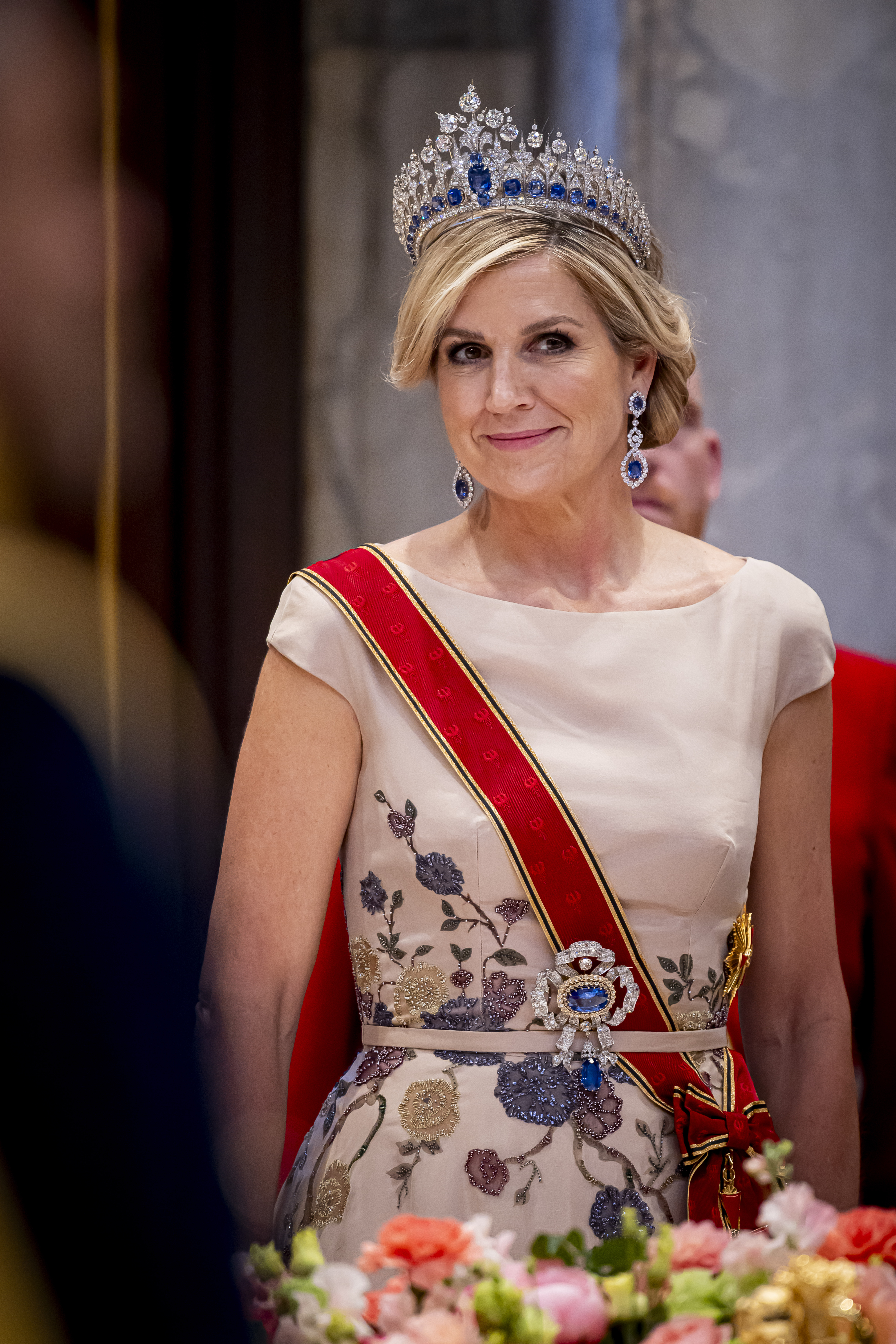 Queen Maxima wearing a diamond and sapphire tiara and a beige gown