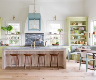 Kitchen with large kitchen island and green cabinetry behind