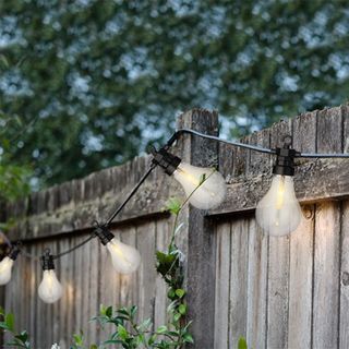 best way to hang string lights in your backyard, string lights on a fence by Ella James