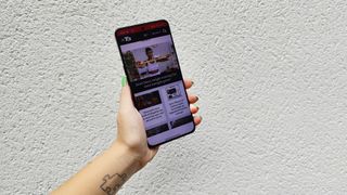 Oppo Reno 8 Pro review: woman holding phone with T3 website open
