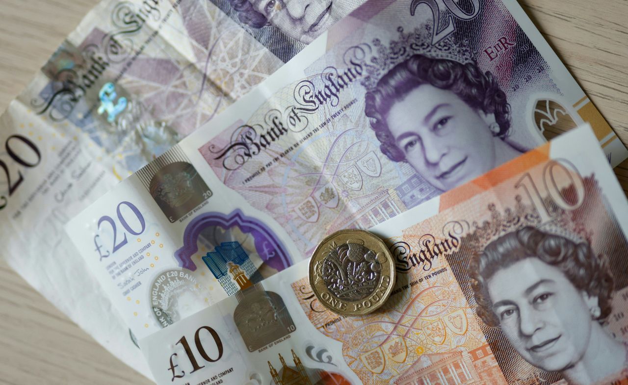 Pound coin and banknotes displayed on a table