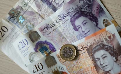 Pound coin and banknotes displayed on a table