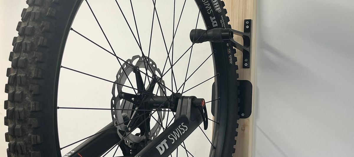 Bike wheel attached to hook on wall