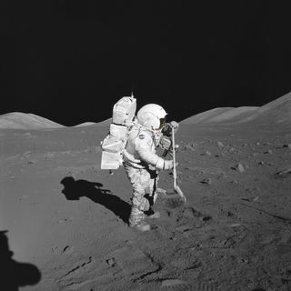 Harrison H. Schmitt raking the surface of the moon.