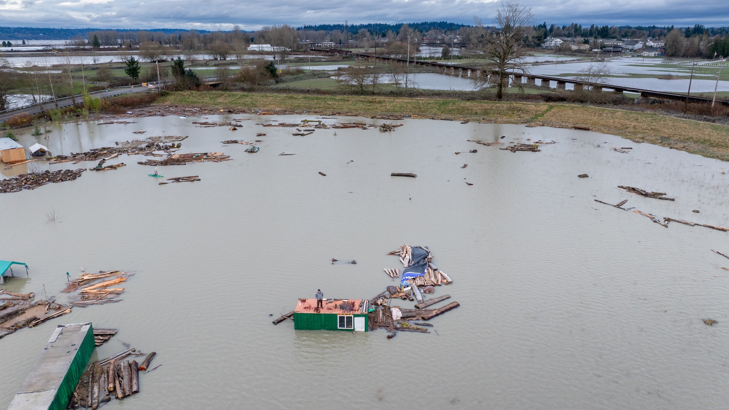 A man stands on a roof in a flooded area