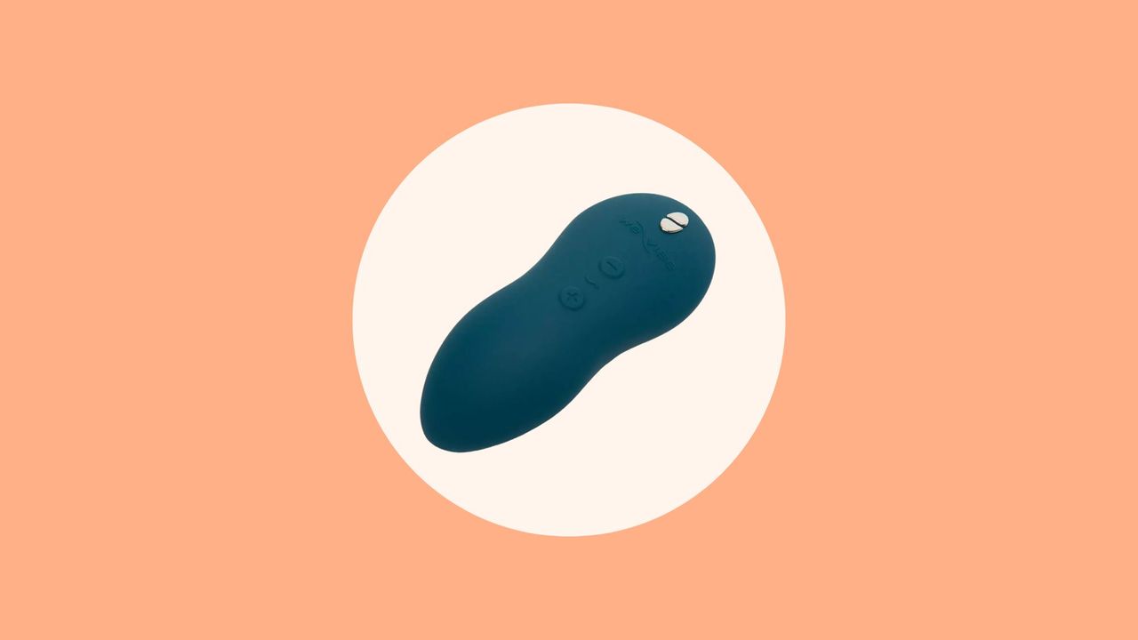 We-Vibe Touch X review image of the Touch X vibrator in dark blue on a cream and orange background