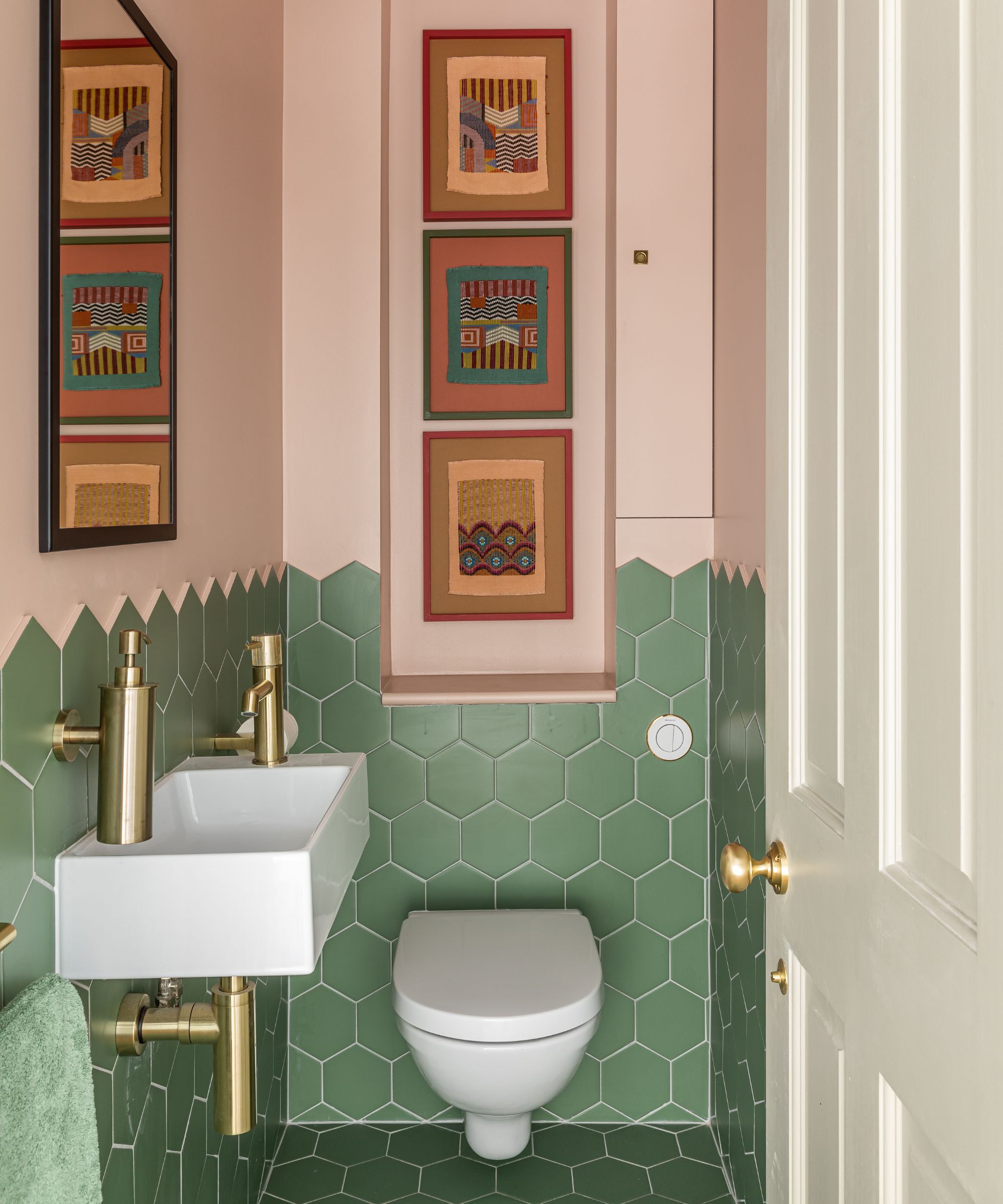 A downstairs toilet with walls half painted in Farrow & Ball Setting Plaster, the other half in green hexagonal tiles.