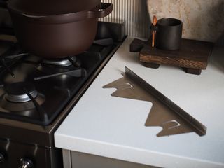 a stove gap filler on a countertop next to a stove with a pot on