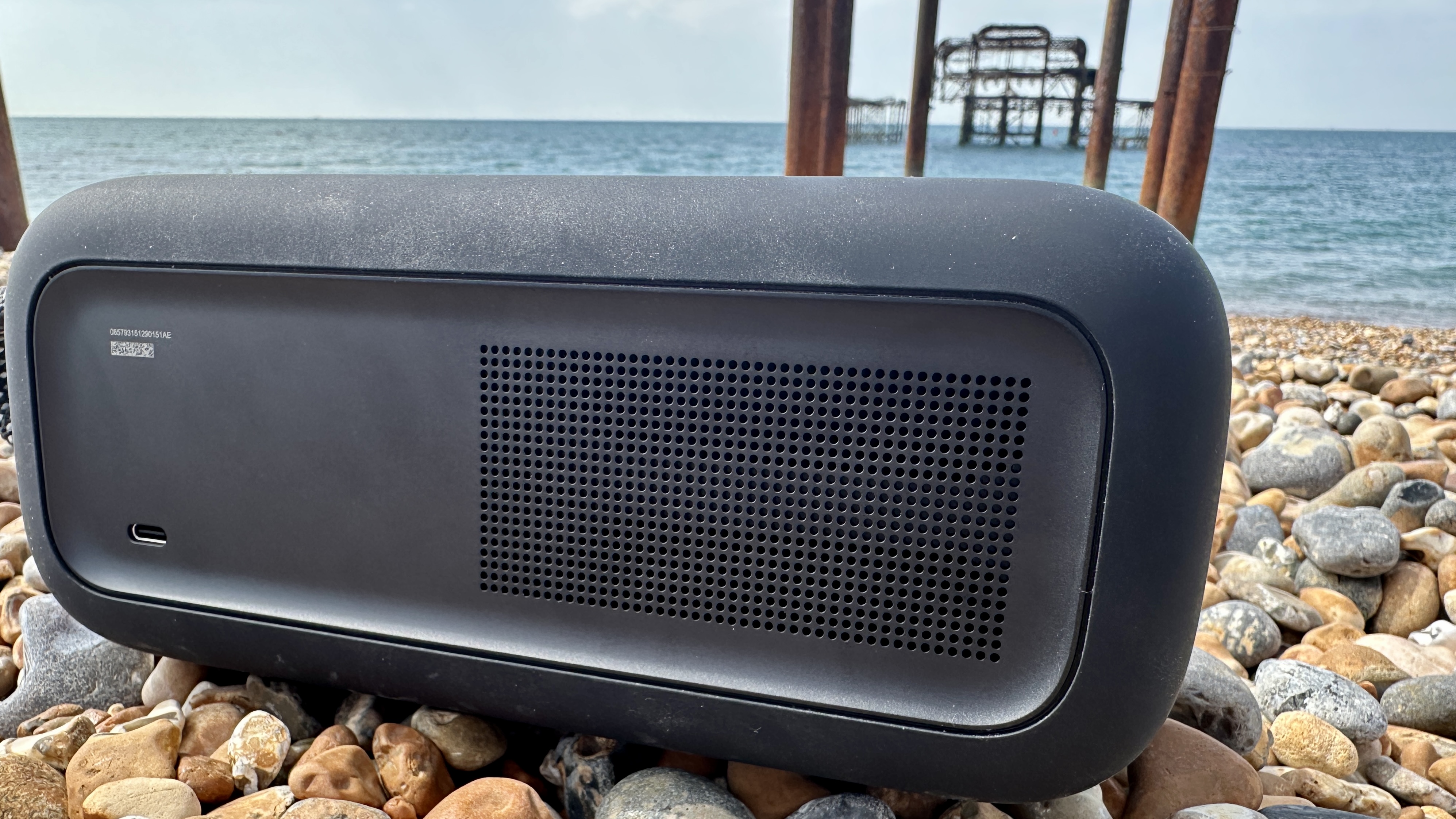 Bose SoundLink Plus on Brighton Beach pebbles, with the old pier in the background