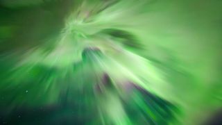 aurora overhead known as a corona whereby huge green curtains of light stretch down from the sky during an intense northern lights show.