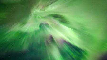 aurora overhead known as a corona whereby huge green curtains of light stretch down from the sky during an intense northern lights show.
